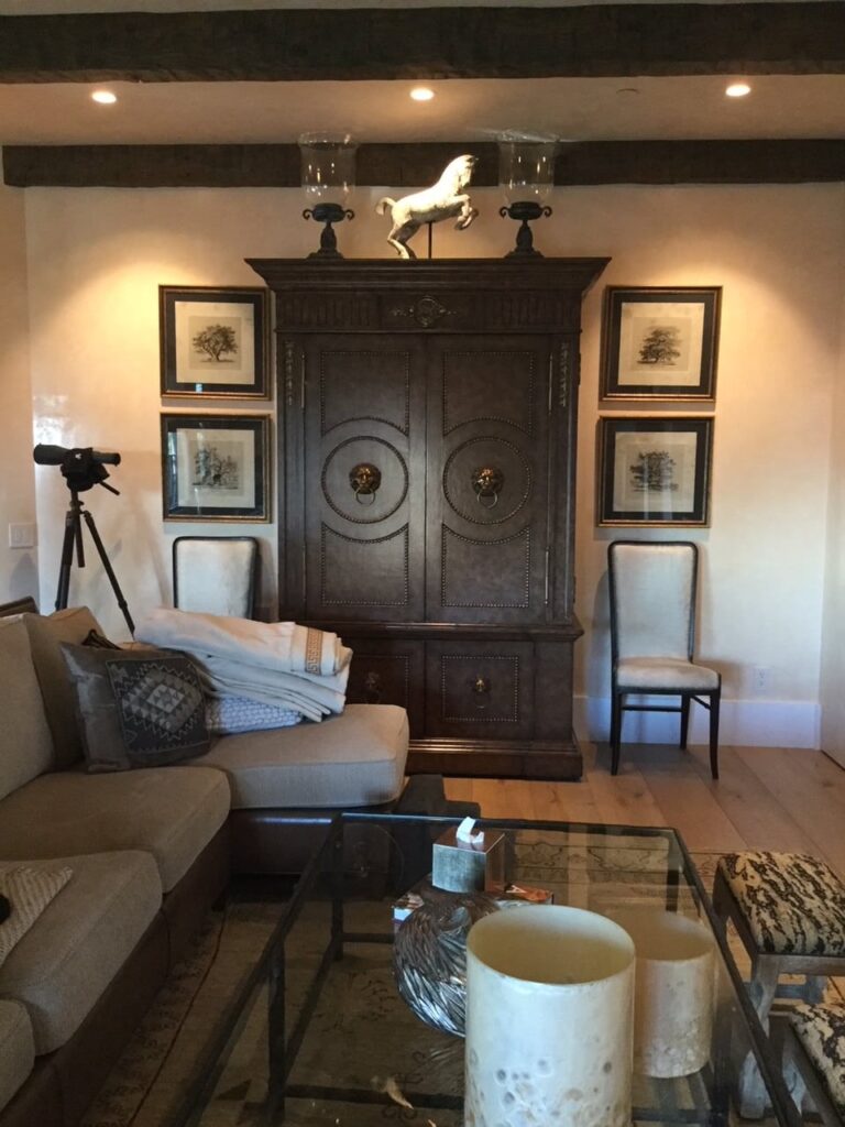 Sophisticated living room area with a coffee table, couch and large dark wood cabinet